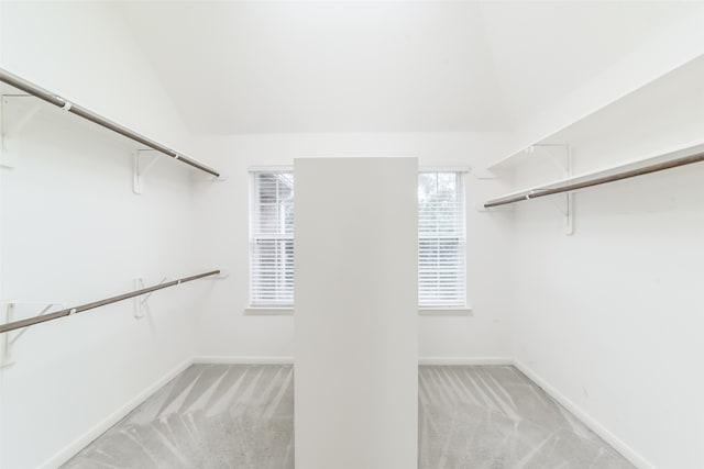 walk in closet featuring light colored carpet and vaulted ceiling