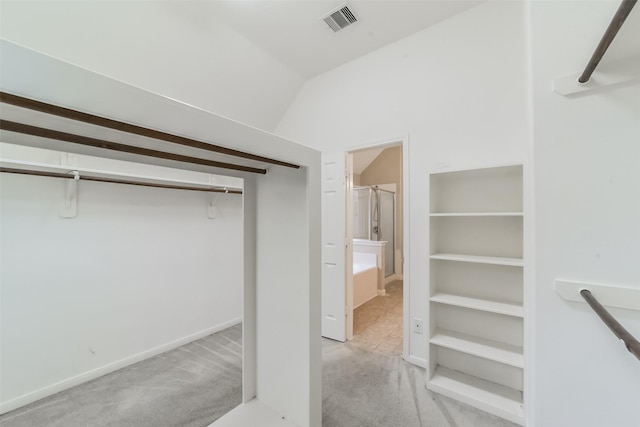 walk in closet with lofted ceiling, carpet, and visible vents