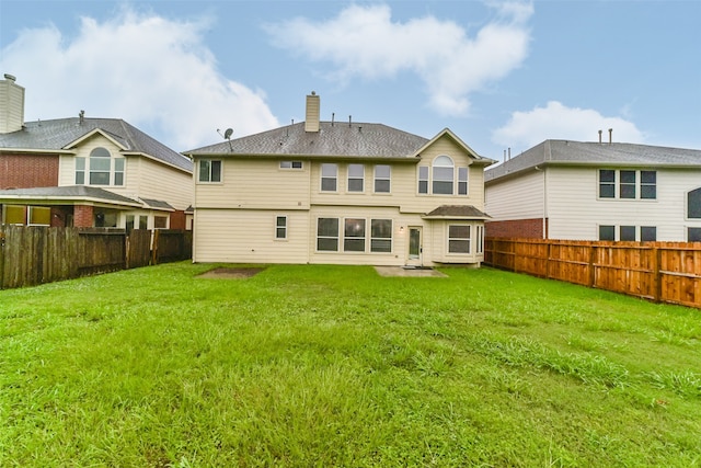 back of house featuring a lawn