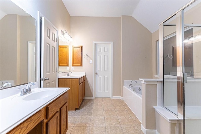 bathroom featuring a garden tub, a stall shower, a sink, tile patterned flooring, and vaulted ceiling