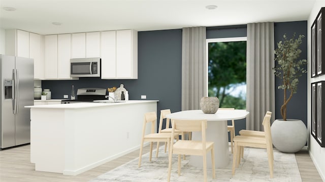 kitchen featuring white cabinets, appliances with stainless steel finishes, light hardwood / wood-style flooring, and a healthy amount of sunlight