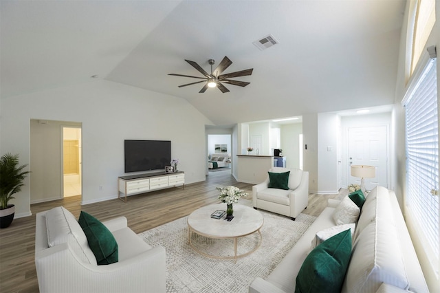 living room with baseboards, visible vents, lofted ceiling, ceiling fan, and wood finished floors