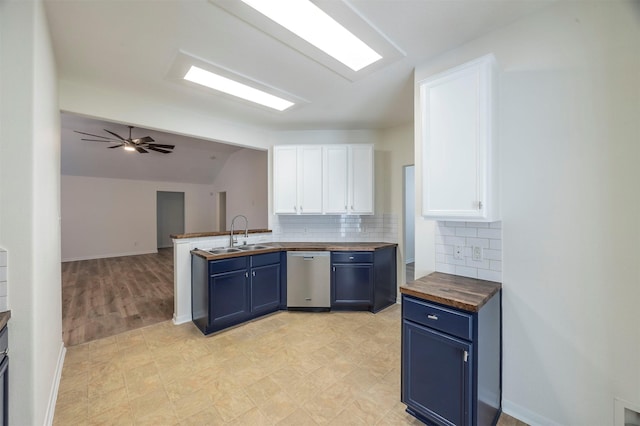 kitchen featuring blue cabinets, butcher block counters, a sink, white cabinets, and dishwasher