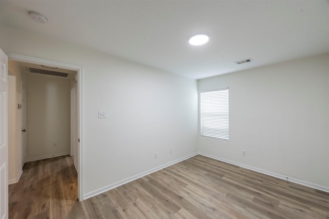 unfurnished room featuring light wood-type flooring, baseboards, and visible vents