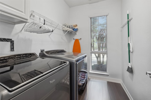 laundry room with separate washer and dryer, cabinets, and wood-type flooring