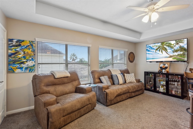 living room featuring carpet, ceiling fan, and a tray ceiling