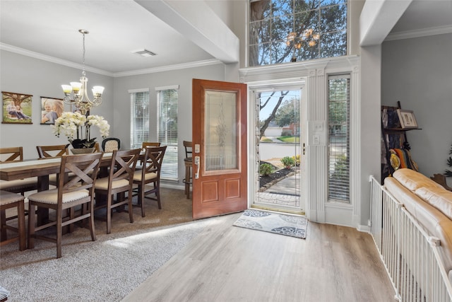 entrance foyer featuring a notable chandelier, plenty of natural light, ornamental molding, and light hardwood / wood-style flooring