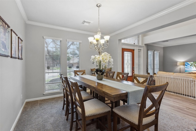 dining space with crown molding, hardwood / wood-style flooring, and a notable chandelier