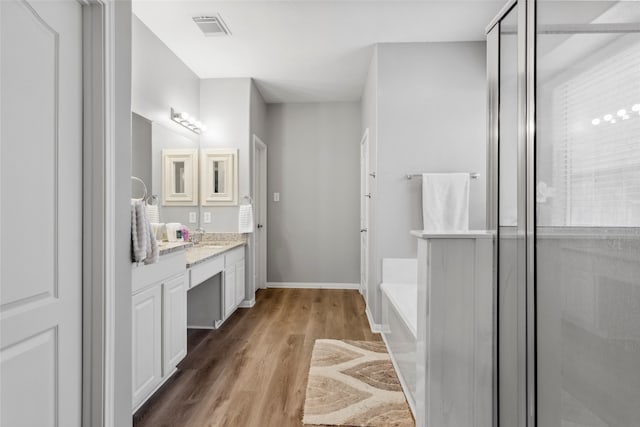 bathroom featuring hardwood / wood-style floors, vanity, and separate shower and tub