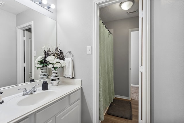 bathroom featuring wood-type flooring, vanity, and a textured ceiling