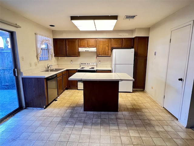 kitchen featuring sink, a kitchen island, and white appliances