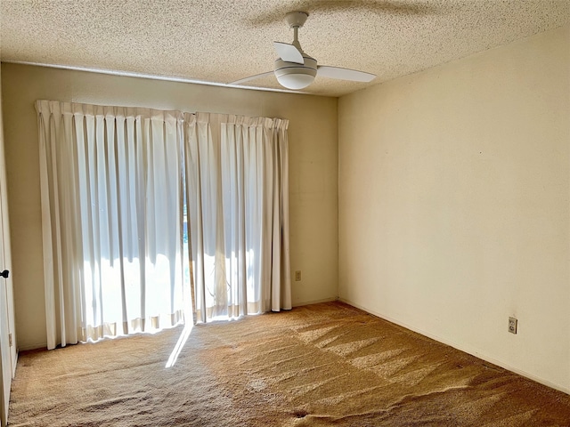 carpeted spare room with ceiling fan and a textured ceiling