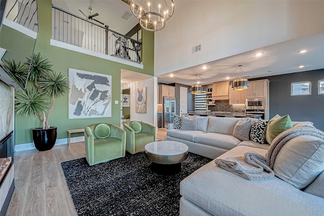 living room with a towering ceiling and light wood-type flooring