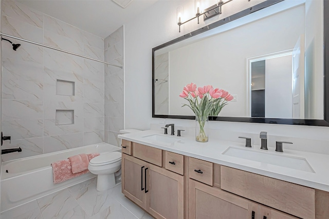 full bathroom featuring tiled shower / bath, vanity, and toilet