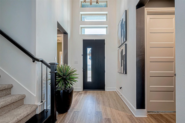 entrance foyer with light hardwood / wood-style floors and a high ceiling