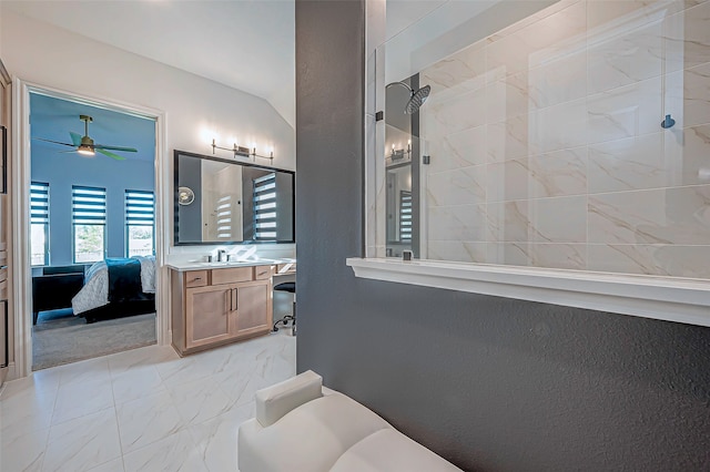 bathroom with a shower, vaulted ceiling, vanity, and ceiling fan