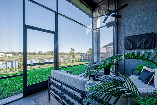 sunroom with a water view and ceiling fan