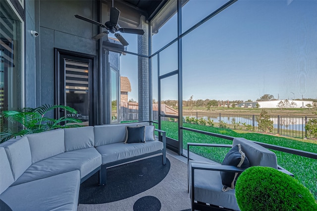 sunroom / solarium with ceiling fan and a water view