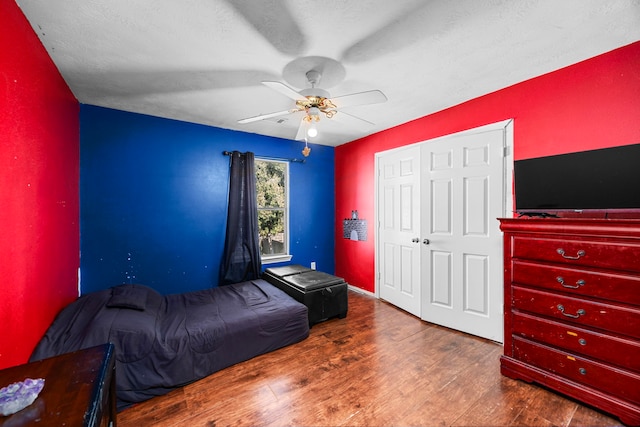 bedroom with a textured ceiling, ceiling fan, a closet, and dark hardwood / wood-style floors