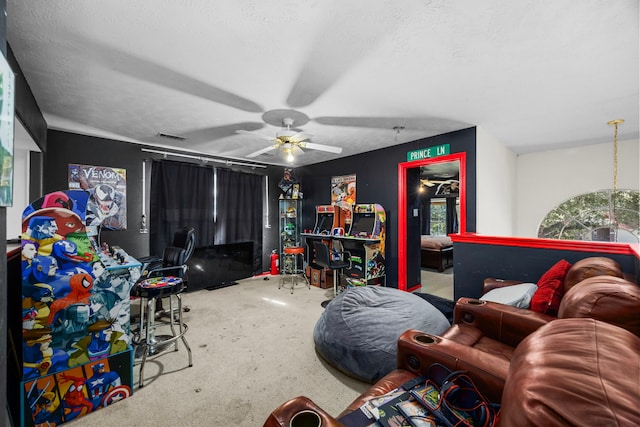 recreation room featuring ceiling fan, carpet, and a textured ceiling