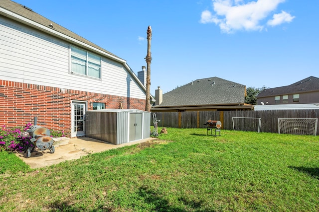 view of yard with a storage shed and a patio