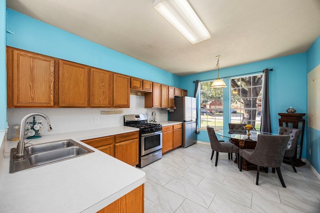 kitchen featuring sink, hanging light fixtures, and appliances with stainless steel finishes