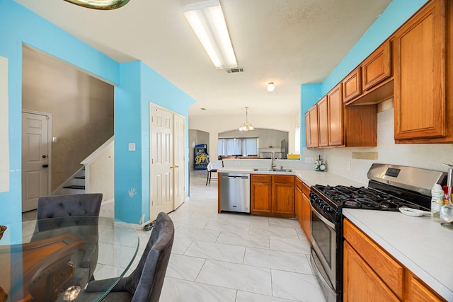 kitchen featuring kitchen peninsula, stainless steel appliances, sink, hanging light fixtures, and lofted ceiling