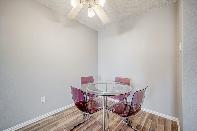 dining room with ceiling fan, a textured ceiling, and light hardwood / wood-style flooring