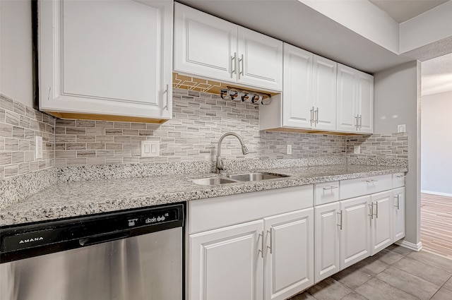 kitchen with decorative backsplash, dishwasher, white cabinets, and sink