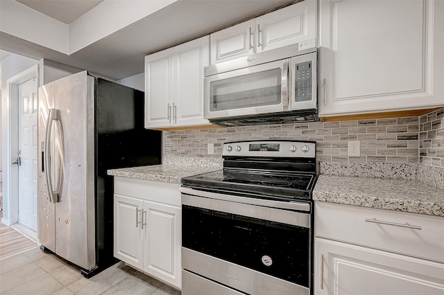 kitchen with white cabinetry, stainless steel appliances, and tasteful backsplash