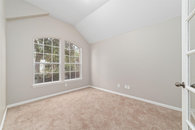 unfurnished room featuring light carpet and lofted ceiling