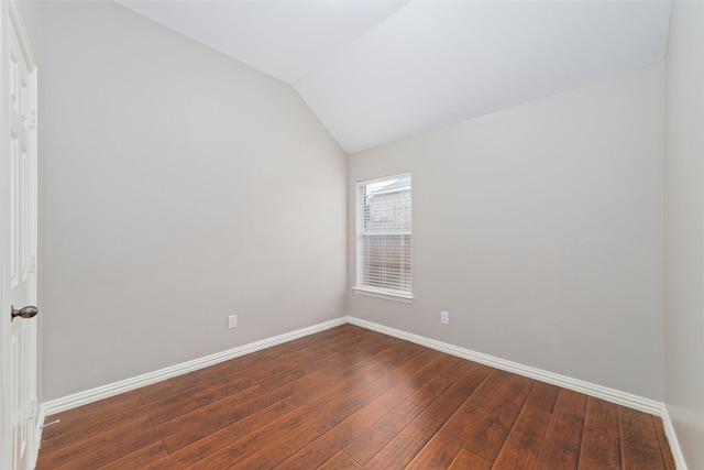 unfurnished room featuring dark hardwood / wood-style floors and vaulted ceiling