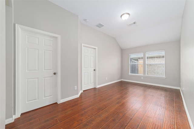 interior space with dark hardwood / wood-style flooring and vaulted ceiling