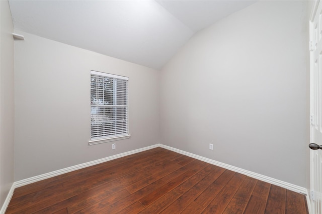 spare room with vaulted ceiling and hardwood / wood-style flooring