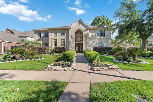 view of front of property featuring a front yard and french doors