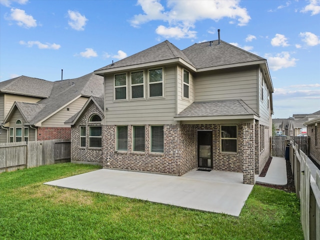 back of property with a lawn and a patio area