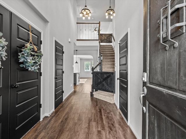 foyer featuring dark hardwood / wood-style floors, a high ceiling, and an inviting chandelier