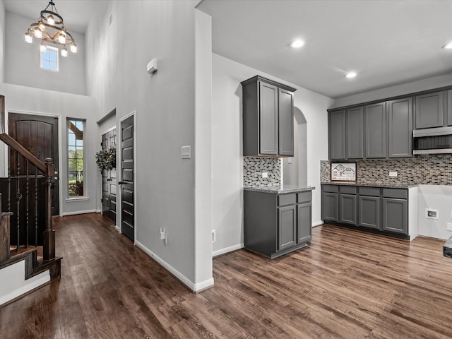 kitchen with decorative light fixtures, dark wood-type flooring, tasteful backsplash, and gray cabinetry