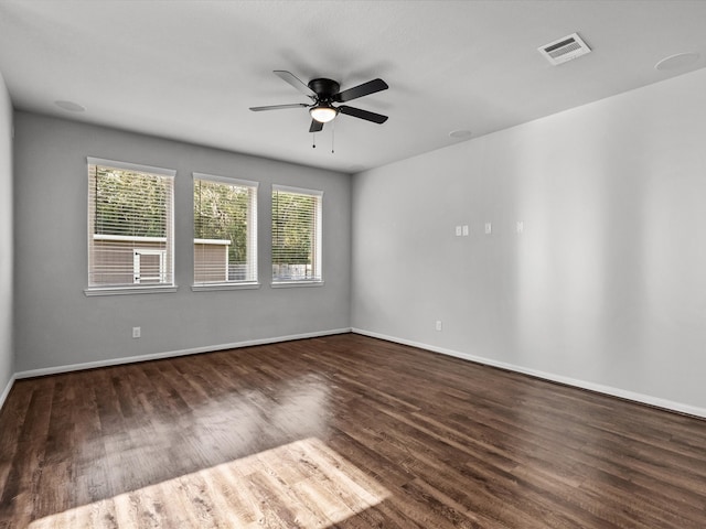 empty room with dark hardwood / wood-style floors and ceiling fan