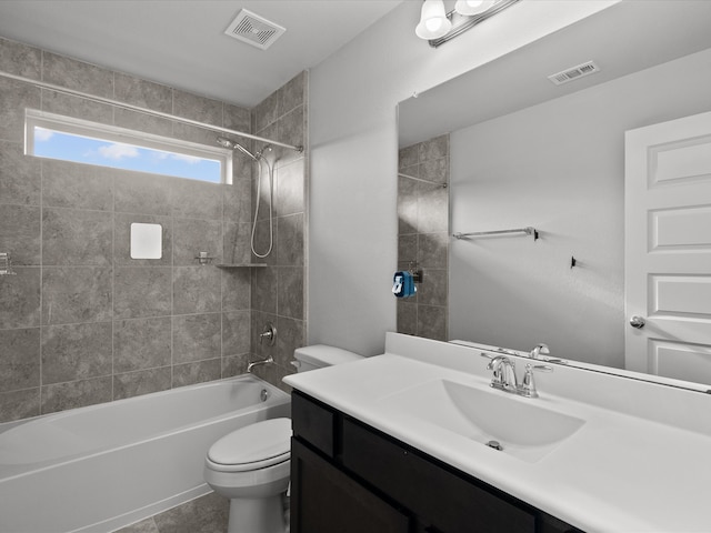 full bathroom with vanity, tiled shower / bath combo, and toilet