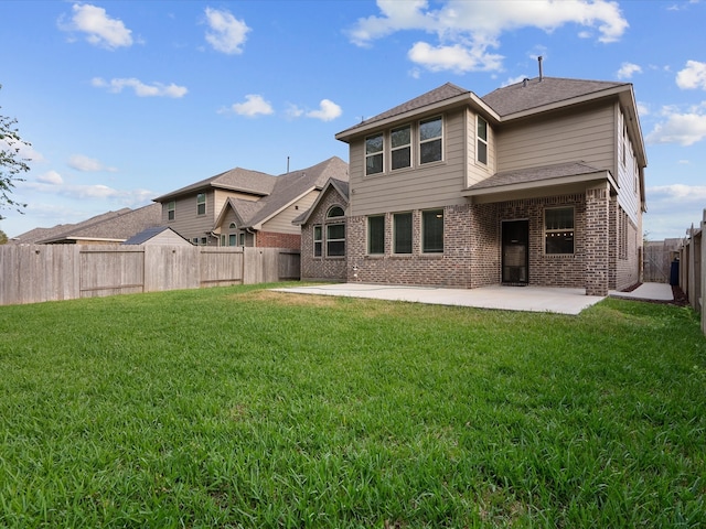 rear view of house featuring a lawn and a patio