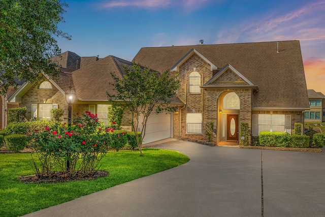 view of front of house with a garage and a lawn