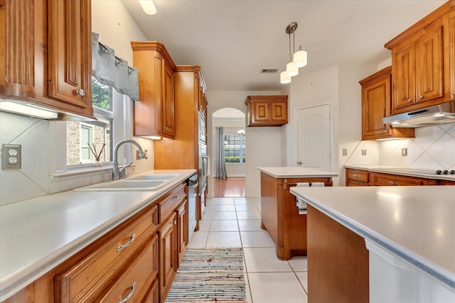 kitchen featuring backsplash, sink, pendant lighting, light tile patterned floors, and stovetop