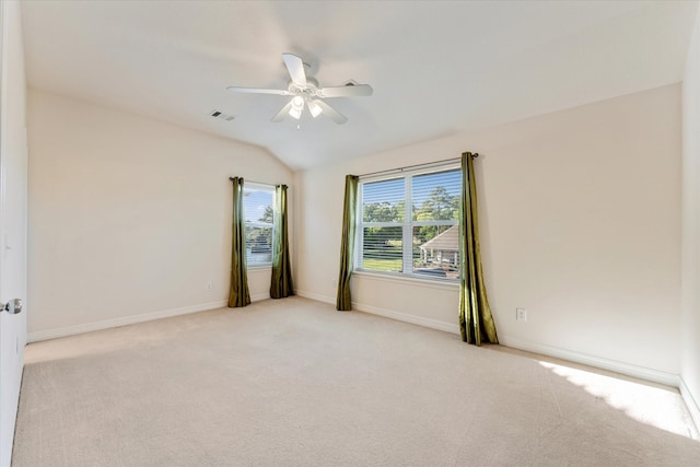 carpeted spare room featuring ceiling fan and lofted ceiling