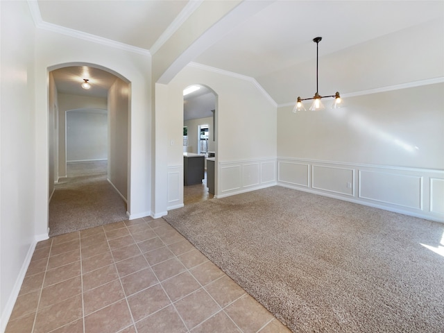 carpeted spare room with a chandelier, lofted ceiling, and crown molding