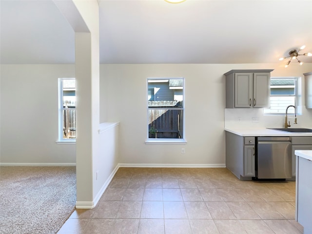 kitchen featuring stainless steel dishwasher, gray cabinetry, sink, and light carpet