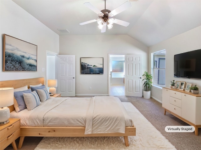 carpeted bedroom with ceiling fan, lofted ceiling, and connected bathroom