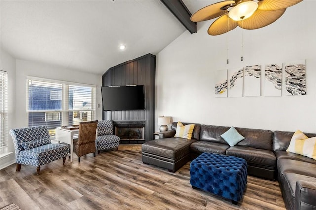 living room featuring ceiling fan, a fireplace, lofted ceiling with beams, and hardwood / wood-style flooring