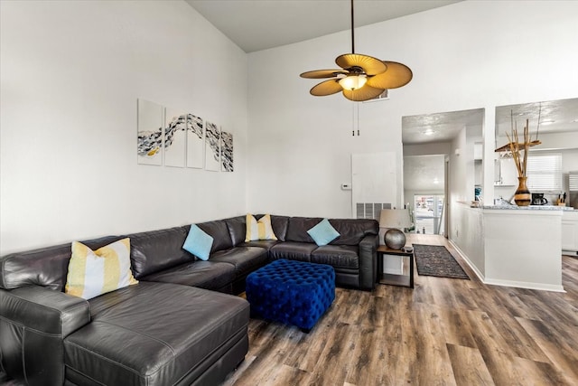 living room featuring high vaulted ceiling, ceiling fan, and dark wood-type flooring