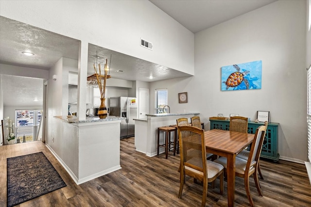 dining space with a textured ceiling, sink, and dark hardwood / wood-style floors